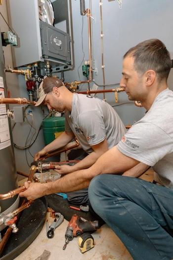 Technicians working on installing copper piping